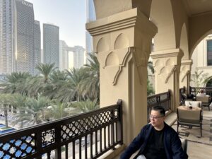 中野和幸がドバイの壮大な風景を前にテラスでくつろいでいる画像
