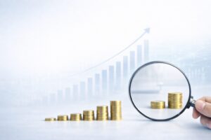 少額の積み上げにも将来の大きな成長につながる価値があることを表したコインと虫眼鏡のイメージ